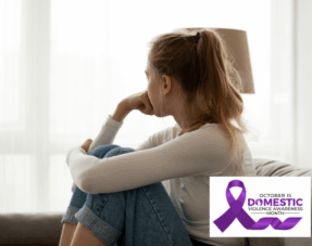 Young woman sitting alone indoors looking thoughtful, representing a domestic abuse survivor, with a purple ribbon graphic for Domestic Violence Awareness Month.