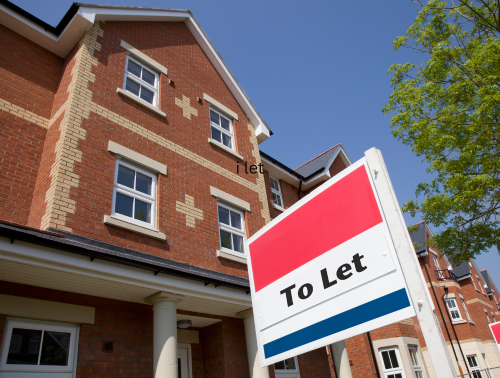 Image of a "to let" sign in front of a residential property.