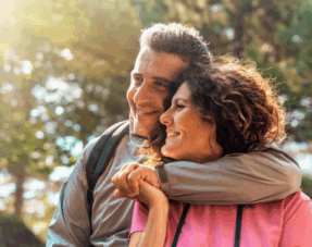 Image of an older couple embracing outdoors.