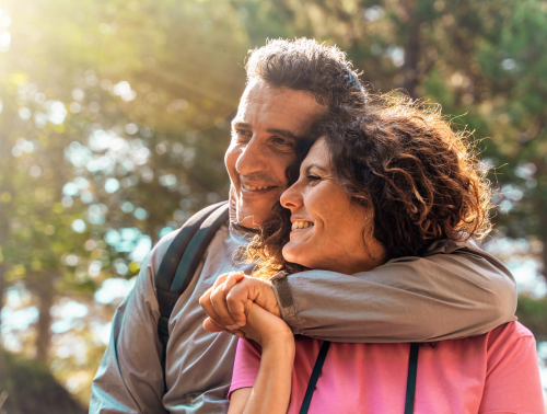 Image of an older couple embracing outdoors.