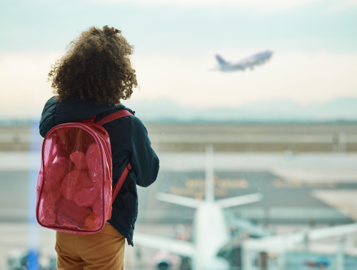 Image of a child looking out of an airport window.