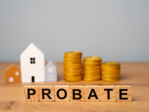 Image of wooden blocks spelling out 'probate' with wooden houses and coins in the background.